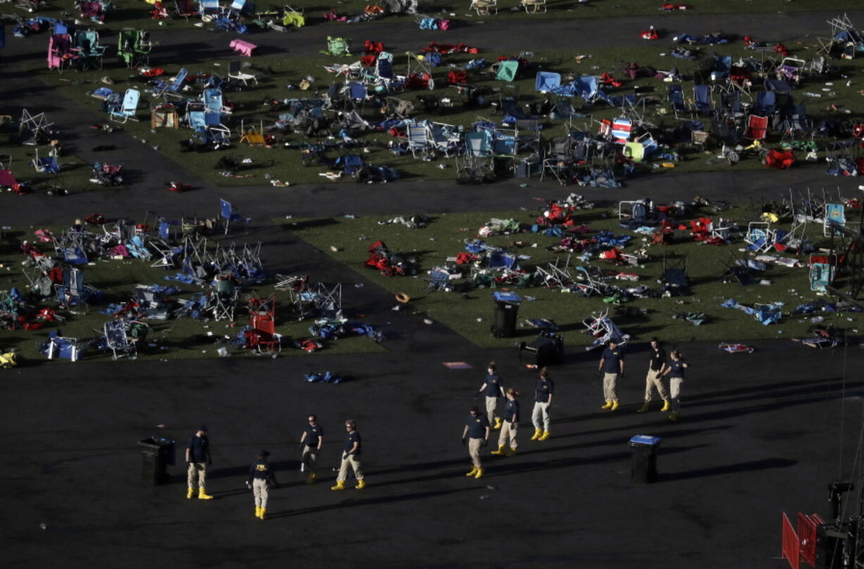 FILE - Investigators work at a festival grounds across the street from the Mandalay Bay Resort and Casino on Oct. 3, 2017, in Las Vegas after a mass shooting. The Nevada Supreme Court cited a state law that shields gun manufacturers from liability unless the weapon malfunctions in a new ruling that says they cannot be held responsible for the deaths in the 2017 mass shooting on the Las Vegas Strip.