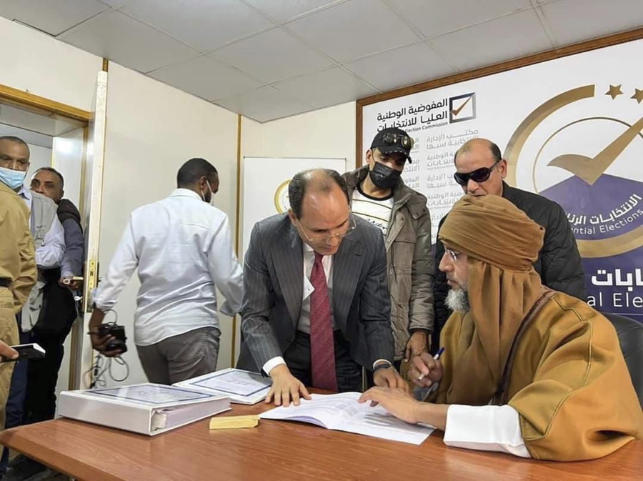 FILE - Seif al-Islam, right, the son and one-time heir apparent of late Libyan dictator Moammar Gadhafi registers his candidacy for the country's presidential elections next month, in Sabha, Libya, Sunday, Nov. 14, 2021. A Libyan parliamentary committee said Wednesday, Dec. 21, that it has become "impossible" to hold a long-awaited presidential vote in two days as scheduled, in a major blow to international efforts to end a decade of chaos in the oil-rich country.