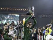 Portland Timbers midfielder Diego Valeri (8) holds up the Western Conference trophy following the team's 2-0 victory over Real Salt Lake in the MLS soccer Western Conference final Saturday, Dec. 4, 2021, in Portland, Ore.