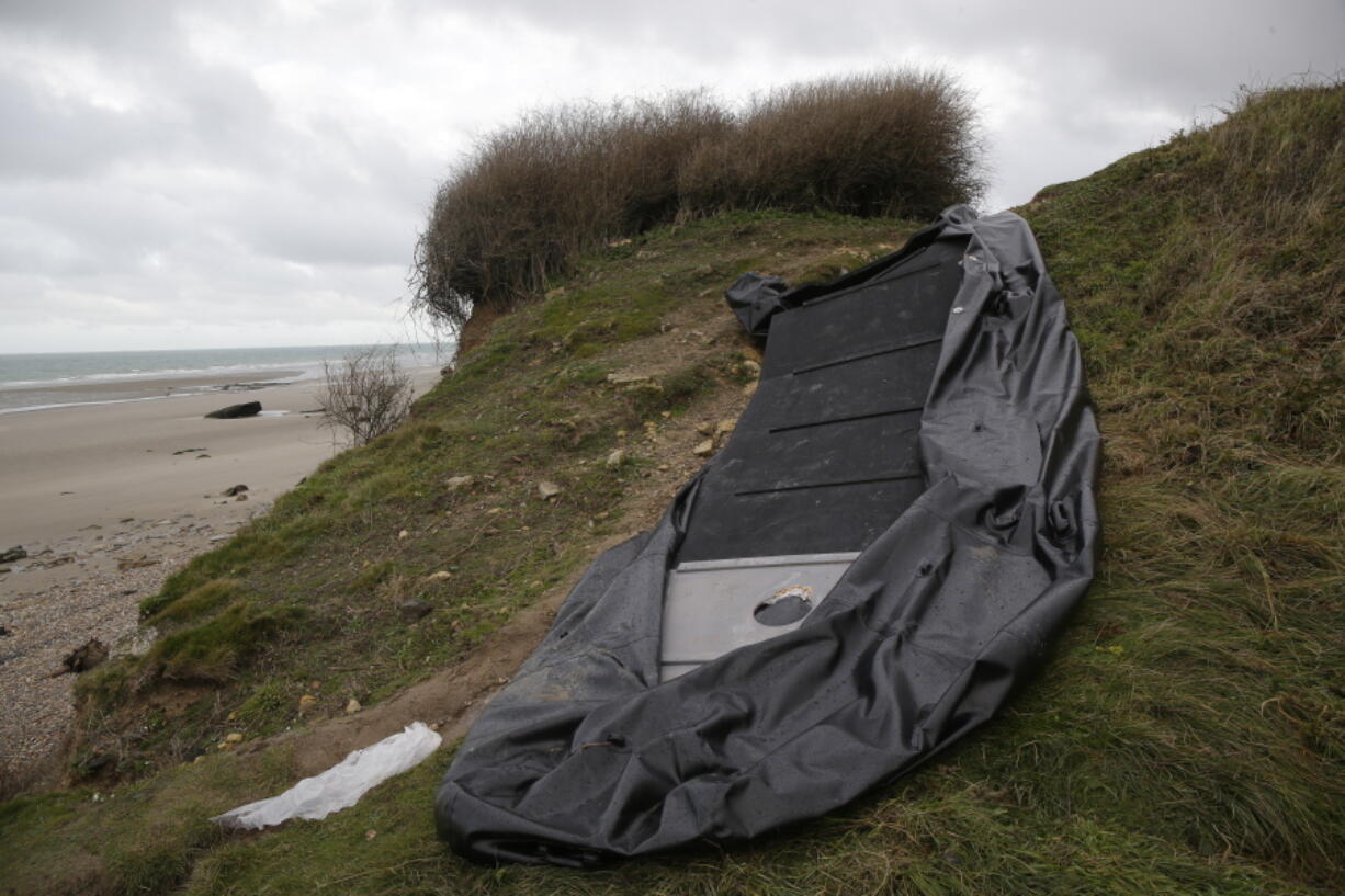 A damaged inflatable small boat is pictured on the shore in Wimereux, northern France, Thursday, Nov. 25, 2021 in Calais, northern France. Children and pregnant women were among at least 27 migrants who died when their small boat sank in an attempted crossing of the English Channel, a French government official said Thursday.