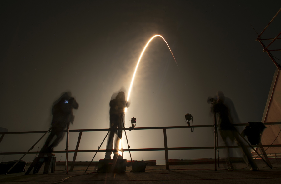 Photographers follow a SpaceX Falcon 9 rocket during a time exposure as it lifts off from Launch Complex 39A at the Kennedy Space Center in Cape Canaveral, Fla., Thursday, Dec. 9, 2021.