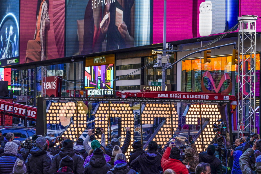 FILE - The 2022 sign that will be lit on top of a building on New Year's Eve is displayed in Times Square, New York, Monday, Dec. 20, 2021. New York City is readying to embrace the new year by reviving its annual New Year's Eve celebration in Times Square--limiting the number of people to about 15,000 in-person spectators.