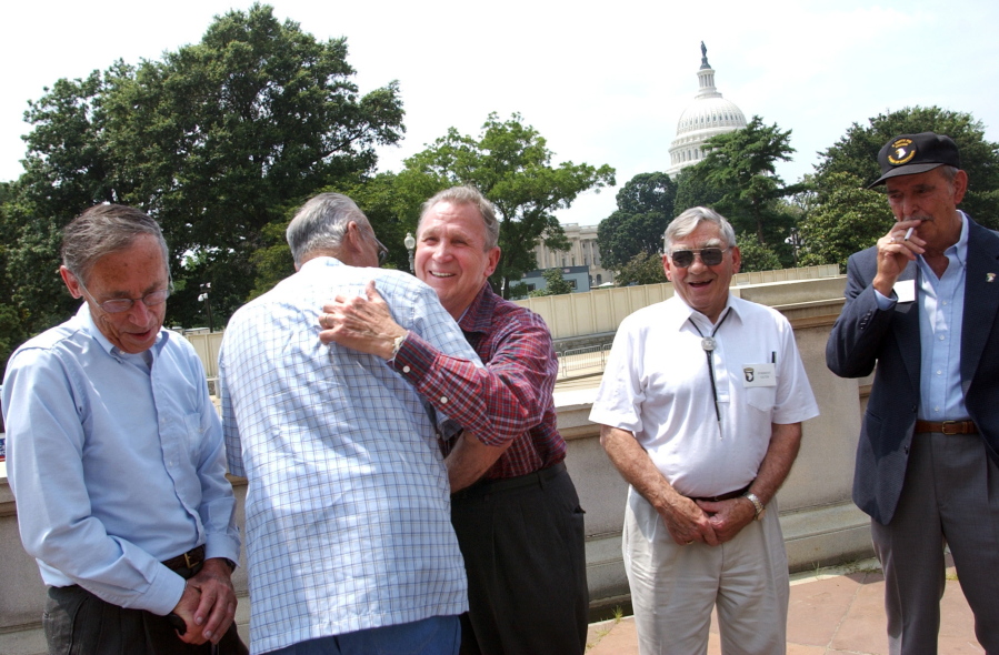 FILE - Edward Shames, center, hugs Ed McClung, center left, both members of the World War II Army Company E of the 506th Regiment of the 101st Airborne, with veterans Jack Foley, left, Joe Lesniewski, right, and Shifty Powers, far right, at the Library of Congress in Washington, on July 16, 2003. Shames, who was the last surviving officer of "Easy Company," which inspired the HBO miniseries and book "Band of Brothers," has died at age 99. An obituary posted by the Holomon-Brown Funeral Home & Crematory said Shames, of Norfolk, Va., died peacefully at his home on Friday, Dec. 3, 2021.
