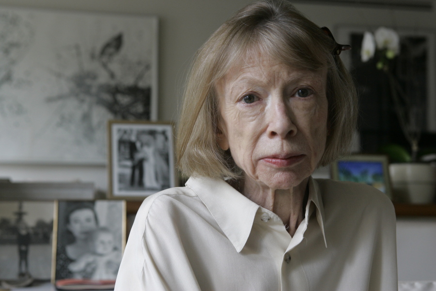 FILE - Author Joan Didion sits in front of a photo of herself holding her daughter, Quintana Roo, and another picture of her daughter's wedding, in her New York apartment Sept. 26, 2005. Didion, the revered author and essayist whose provocative social commentary and detached, methodical literary voice made her a uniquely clear-eyed critic of a uniquely turbulent time, has died. She was 87.