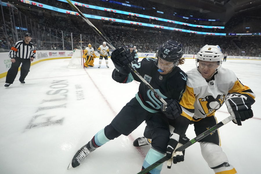 Seattle Kraken center Mason Appleton, left, and Pittsburgh Penguins defenseman Chad Ruhwedel, right, go up against the boards during the first period of an NHL hockey game, Monday, Dec. 6, 2021, in Seattle. (AP Photo/Ted S.