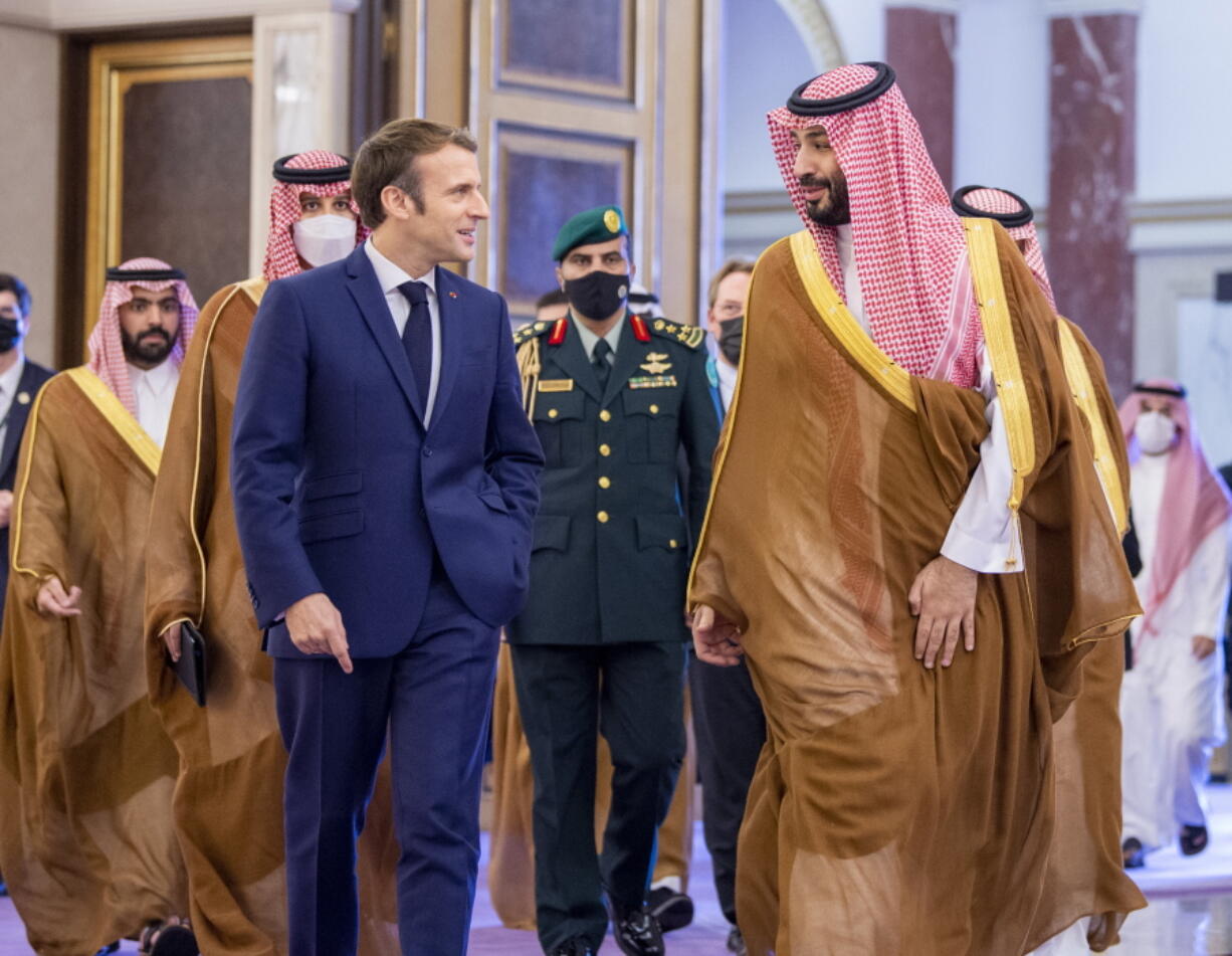 In this photo released by Saudi Royal Palace, Saudi Crown Prince Mohammed bin Salman greets French President Emmanuel Macron, left, upon his arrival in Jiddah, Saudi Arabia, Saturday, Dec. 4, 2021.