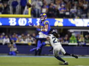 Los Angeles Rams wide receiver Cooper Kupp, top, catches a pass over Seattle Seahawks cornerback Sidney Jones during the second half of an NFL football game Tuesday, Dec. 21, 2021, in Inglewood, Calif.