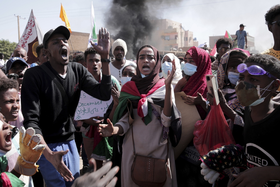 People chant slogans during a protest to denounce the October military coup, in Khartoum, Sudan, Saturday, Dec. 25, 2021.