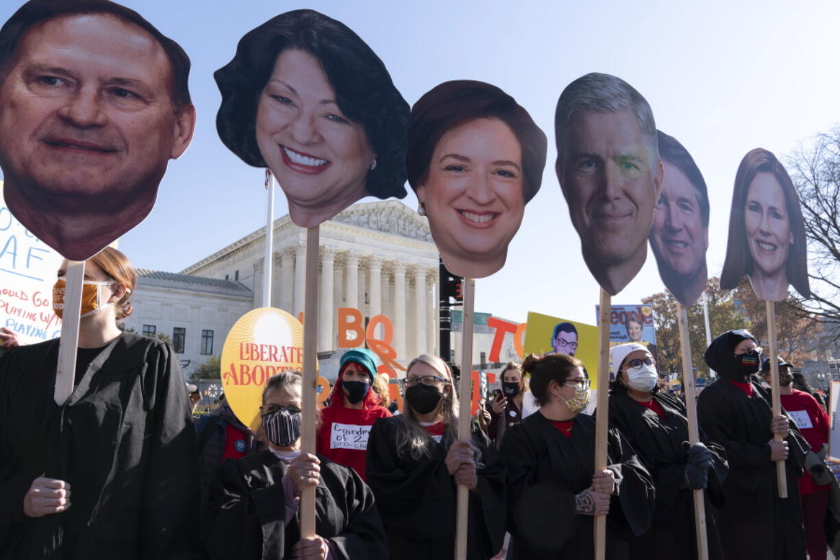 Abortion rights advocates holding cardboard cutouts of the Supreme Court Justices, demonstrate in front of the U.S. Supreme Court Wednesday, Dec. 1, 2021, in Washington, as the court hears arguments in a case from Mississippi, where a 2018 law would ban abortions after 15 weeks of pregnancy, well before viability.