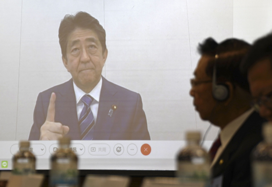 Former Japanese Prime Minister Shinzo Abe, seen on a screen, during a meeting in Taipei, Wednesday Dec. 1, 2021. China lashed out at Shinzo Abe Wednesday, Dec. 1, 2021, after the former Japanese prime minister warned of the serious security and economic consequences of any Chinese military action against the self-ruled island.