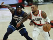Portland Trail Blazers guard Damian Lillard, left, drives against Minnesota Timberwolves guard Patrick Beverley, left, during the first half of an NBA basketball game in Portland, Ore., Sunday, Dec. 12, 2021.