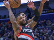 Portland Trail Blazers guard Damian Lillard (0) loses the ball as he collides withNew Orleans Pelicans forward Herbert Jones during the first half of an NBA basketball game in New Orleans, Tuesday, Dec. 21, 2021.