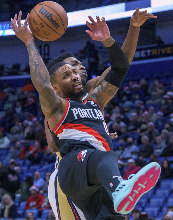 Portland Trail Blazers guard Damian Lillard (0) loses the ball as he collides withNew Orleans Pelicans forward Herbert Jones during the first half of an NBA basketball game in New Orleans, Tuesday, Dec. 21, 2021.