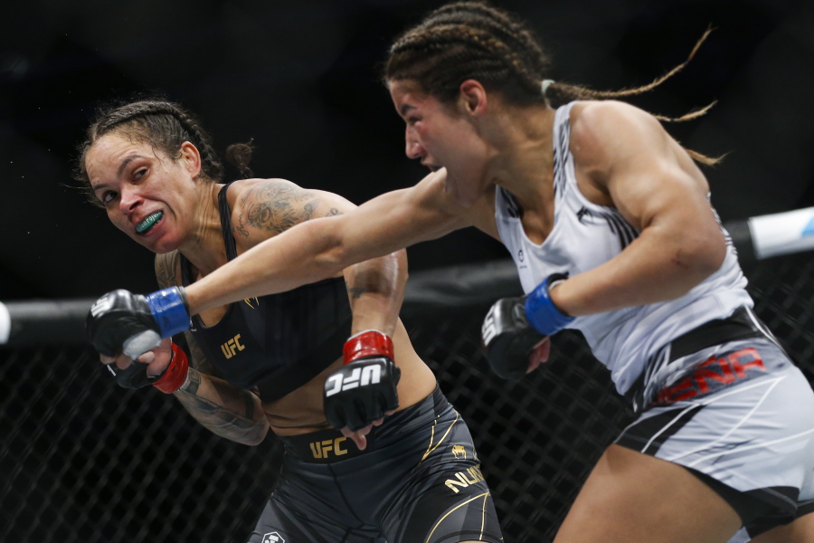Julianna Pena, right, throws a right to Amanda Nunes during a women's bantamweight mixed martial arts title bout at UFC 269, Saturday, Dec. 11, 2021, in Las Vegas.