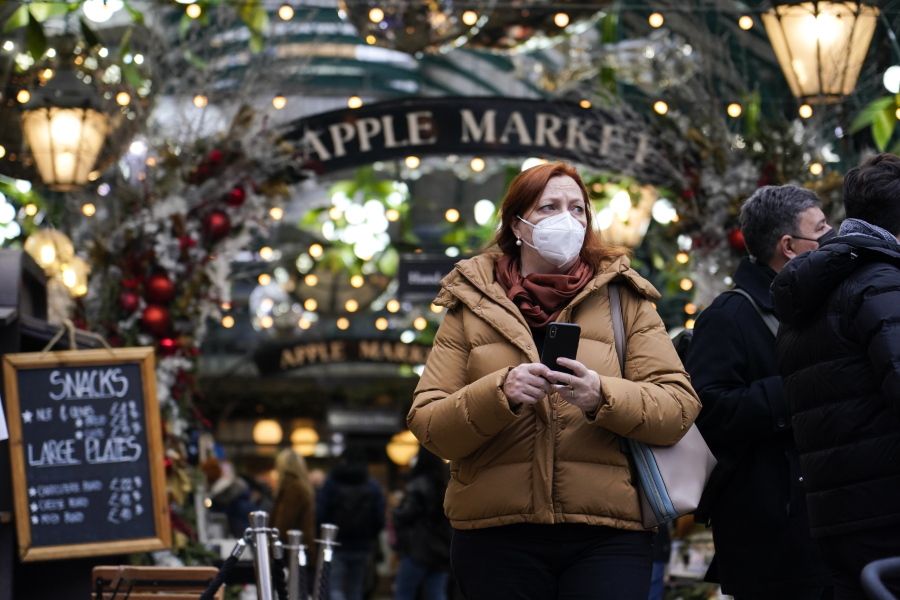 A woman wears a face mask as she walks in Covent Garden market, in London, Thursday, Dec. 16, 2021. The U.K. recorded the highest number of confirmed new COVID-19 infections Wednesday since the pandemic began, and England's chief medical officer warned the situation is likely to get worse as the omicron variant drives a new wave of illness during the Christmas holidays. The U.K. recorded 78,610 new infections on Wednesday, 16% higher than the previous record set in January.