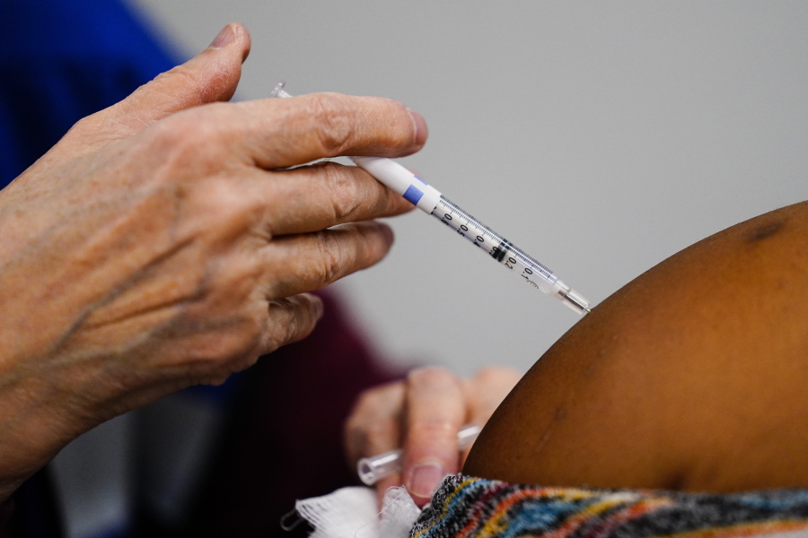A health worker administers a dose of a COVID-19 vaccine during a vaccination clinic at the Keystone First Wellness Center in Chester, Pa., Wednesday, Dec. 15, 2021.