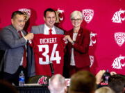 Washington State football coach Jake Dickert stands with Washington State athletic director Pat Chun, left, and Washington State Provost Elizabeth Chilton on Thursday, Dec. 2, 2021, in Pullman, Wash. Dickert was elevated last week from interim coach after the Cougars pounded rival Washington 40-13 in the annual Apple Cup game in Seattle.