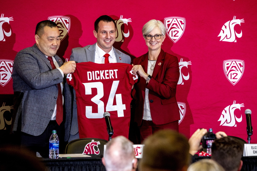 Washington State football coach Jake Dickert stands with Washington State athletic director Pat Chun, left, and Washington State Provost Elizabeth Chilton on Thursday, Dec. 2, 2021, in Pullman, Wash. Dickert was elevated last week from interim coach after the Cougars pounded rival Washington 40-13 in the annual Apple Cup game in Seattle.