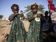 Twins eat slices of watermelon Nov. 25 at the Patte d'Oie district of Ouagadougou, Burkina Faso, where mothers of twins come to beg on the road. In Burkina Faso, a country with a strong belief in the supernatural, twins are regarded as children of spirits whose mothers were specially selected to bear them.