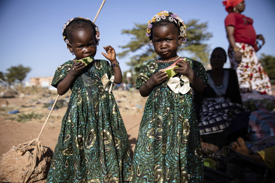Twins eat slices of watermelon Nov. 25 at the Patte d'Oie district of Ouagadougou, Burkina Faso, where mothers of twins come to beg on the road. In Burkina Faso, a country with a strong belief in the supernatural, twins are regarded as children of spirits whose mothers were specially selected to bear them.
