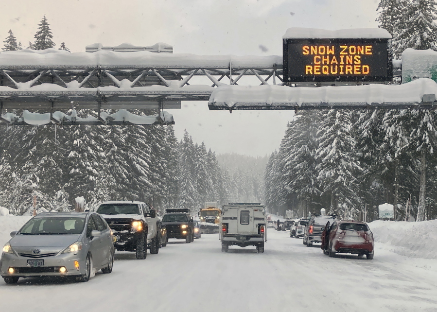 Heavy traffic is seen at the base of a snowy Santiam Pass in Detroit, Ore., Sunday, Dec. 26, 2021. Emergency warming shelters were opened throughout western Washington and Oregon as temperatures plunged into the teens and lower and forecasters said the arctic blast would last for several days.
