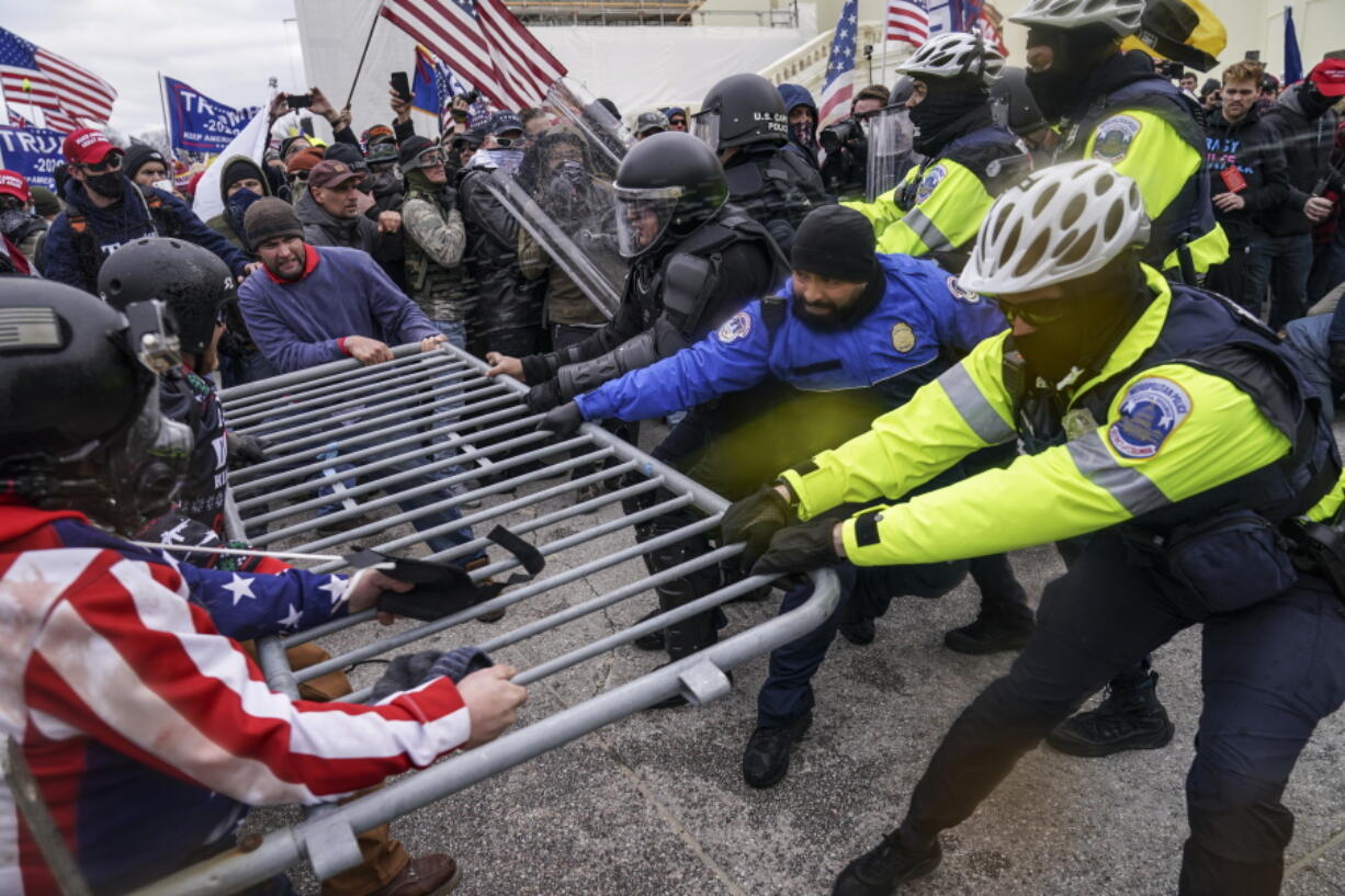 FILE - Rioters try to break through a police barrier at the Capitol in Washington on Jan. 6, 2021. Egged on by soon-to-be former President Donald Trump, a crowd of demonstrators demanded that the electoral vote counting be stopped.
