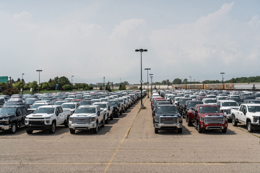 General Motors trucks sit in a gated parking lot next to the Economy Lot across from Bishop International Airport in Flint, Mich., on August 11, 2021.