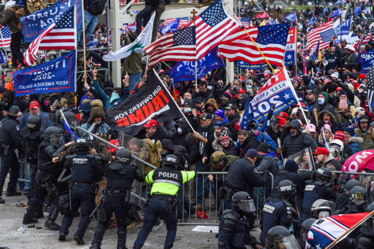 Trump supporters clash with police and security forces as they storm the U.S. Capitol in Washington, D.C., on Jan. 6, 2021. Klete Keller, center left in a teal face covering, gestures during the clash.