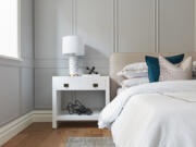 Pure white bedding with a camel detail is paired with a bed of a similar color for a calming vibe.