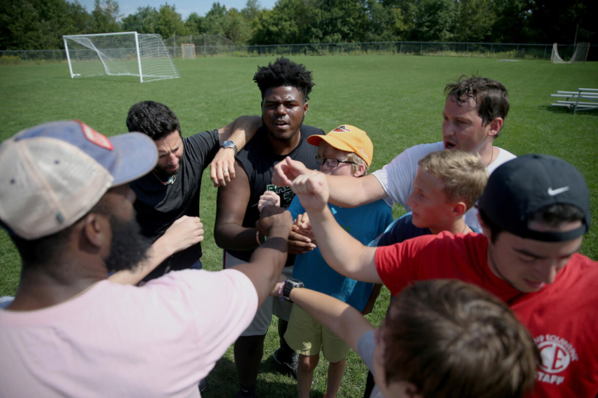 Boys huddle after playing soccer in 2019 during a weeklong camp in Pennsylvania for children grieving the loss of a parent, sibling or caregiver. During the pandemic, more than 167,000 children have lost a parent or caregiver to COVID-19.