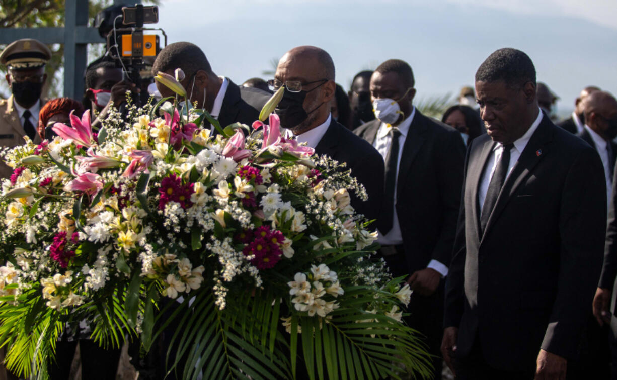 Haitian Prime Minister Ariel Henry lays flowers during an ecumenical Mass in memory of the victims of the 2010 Haiti earthquake, in Port-au-Prince, Jan. 12, 2022.
