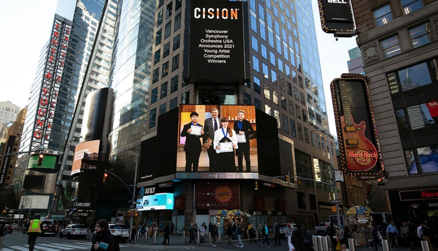 The Vancouver Symphony Orchestra's Young Artists competition has expanded to the national level, which is why this ad featuring Maestro Salvador Brotons and the contest's three winners beamed from Times Square in New York City.