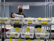 Election board worker Chuck Perine prepares ballots to be recounted by precinct while lending a hand to the recount of two tight races at the Clark County Elections Office on  Nov. 29.