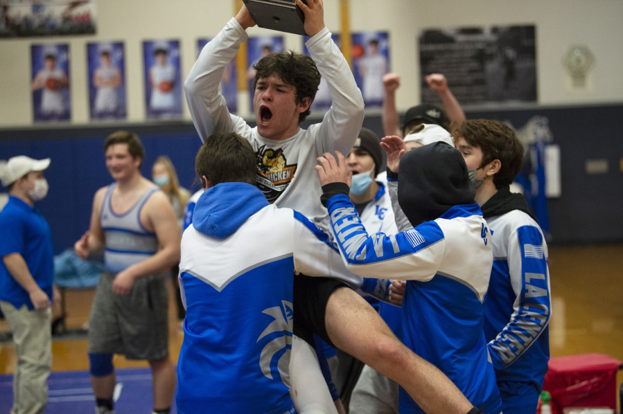 La Center's Austin Mattson is hoisted as he holds the SpudCat Trophy, awarded to the winner of  the Ridgefield-La Center wrestling match. La Center beat Ridgefield 35-30 on Thursday night at La Center on a pin by Leah Wallway at 106 pounds.