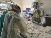 A nurse and respiratory therapist attend to a coronavirus patient in Intensive Care Unit of Arrowhead Regional Medical Center on Wednesday, Dec. 23, 2020 in Colton, California.