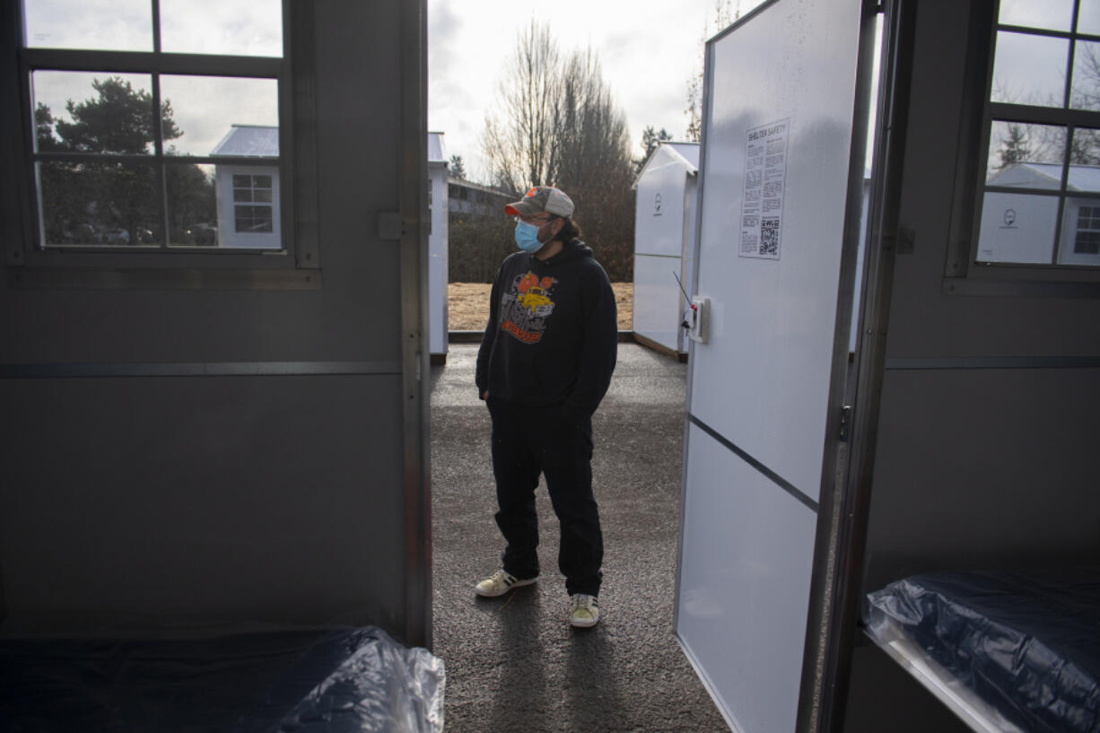 Michael Iverson, a resident of Vancouver's first Stay Safe Community, looks over an empty unit in December.  Outsider's Inn, a Vancouver-based nonprofit, operates the site and connects its residents to resources that can help them transition into permanent housing.