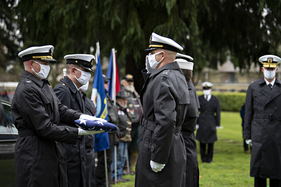 Capt. George Everly, left, and Rear Adm. Scott Ruston, center, join members of a Navy honor guard as they pay tribute to USS Oklahoma sailor Daryle Artley on Monday.