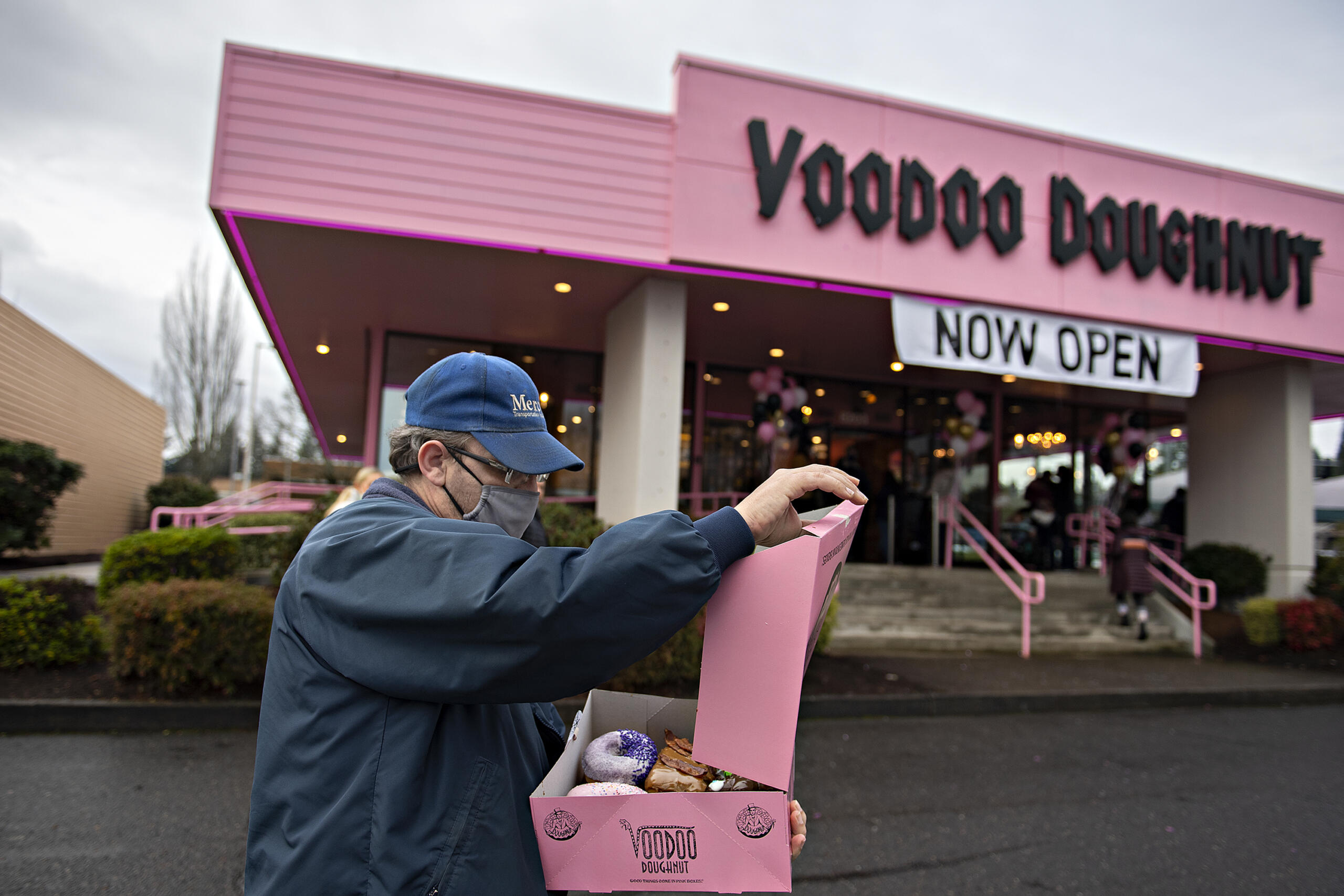 Richard Byers of Vancouver looks over a selection of doughnuts he purchased during the grand opening of the new Voodoo Doughnut at Vancouver Mall on Tuesday morning, Jan.11, 2022.