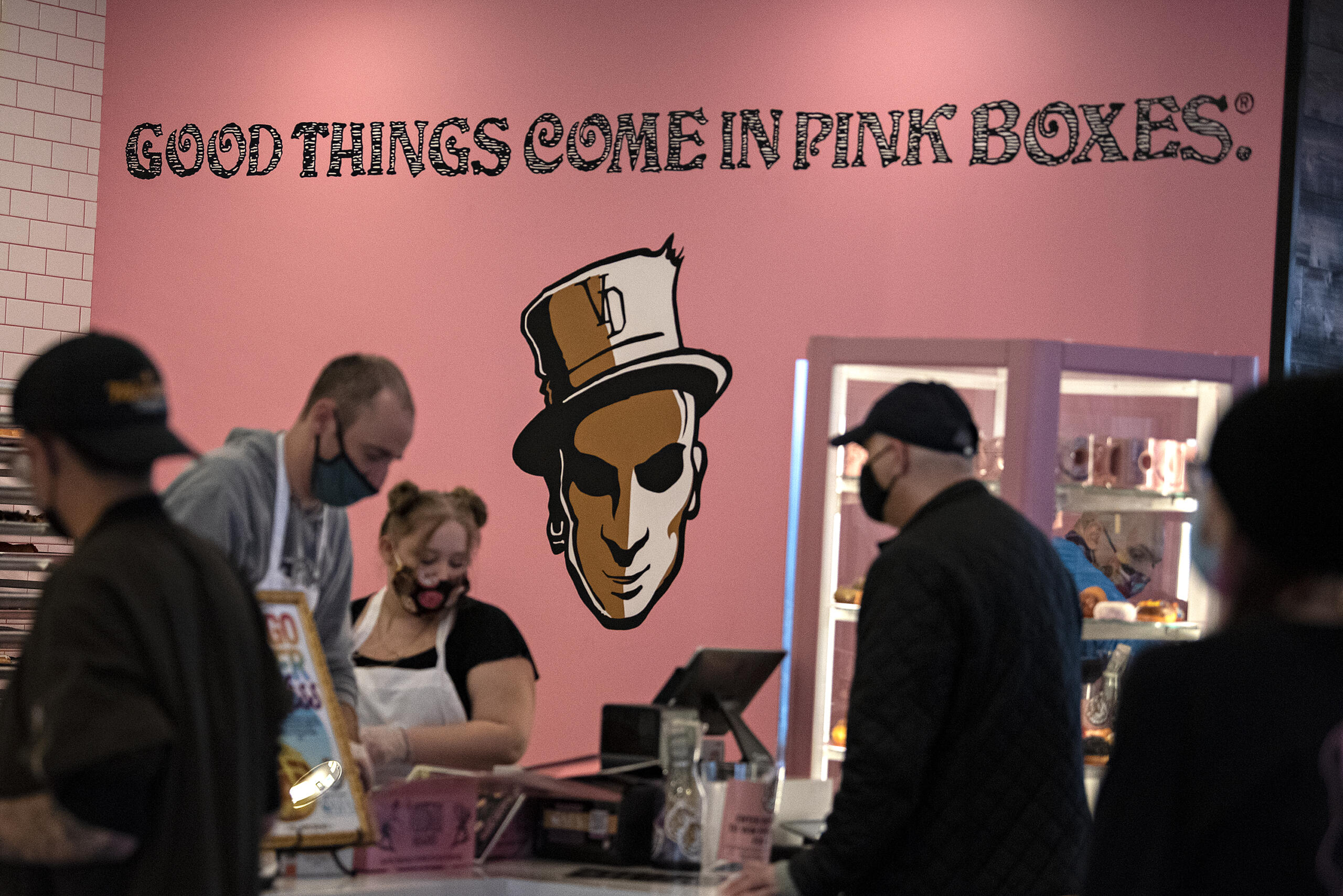 Employees help customers at check-out during the grand opening of the new Voodoo Doughnut at Vancouver Mall on Tuesday morning, Jan.11, 2022.