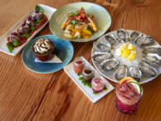 The Cove serves seafood and other dishes. Clockwise from top left are the meatball appetizer; Ora King salmon and prawns; Luna Bella oysters with side sauces; blood orange margarita; chocolate peanut butter pot de creme.