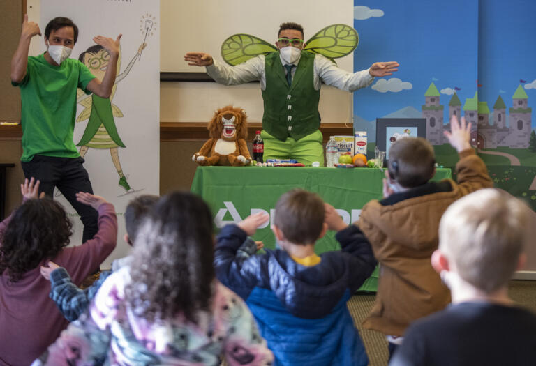 Malcom Reed, center, dressed as the Tooth Fairy, and interpreter Rom Ngov, left, lead a presentation on brushing teeth Tuesday, Jan. 25, 2022, at the Washington School for the Deaf in Vancouver.