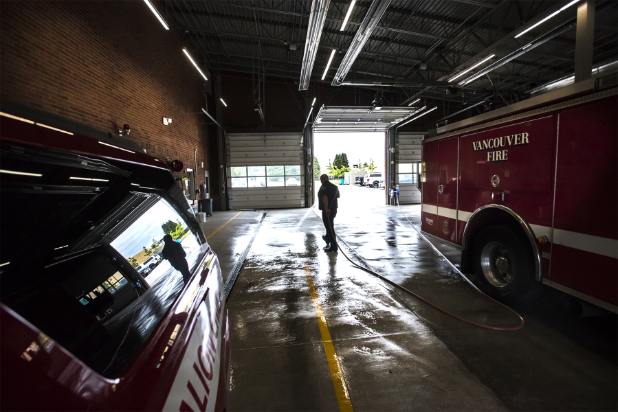 Firefighter Paramedic Lyle Mann hoses down the vehicle bay at Vancouver Fire Station 2. City staff are presenting a measure that would collect $72.7 million in taxes for fire and emergency improvements.