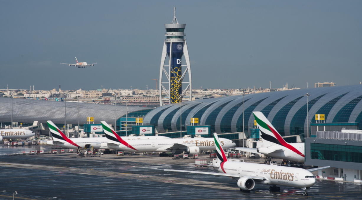 CORRECTS THE YEAR TO 2022, NOT 2021 - FILE - An Emirates jetliner comes in for landing at the Dubai International Airport in Dubai, United Arab Emirates, Dec. 11, 2019. Airlines across the world, including the long-haul carrier Emirates, rushed Wednesday, Jan. 19, 2022, to cancel or change flights heading into the U.S. over an ongoing dispute about the rollout of 5G mobile phone technology near American airports.