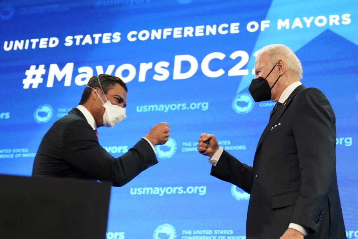 Mayor of Miami Francis Suarez, and president of U.S. Conference of Mayors, knocks knuckles with President Joe Biden after introducing him to speak at the U.S. Conference of Mayors' 90th Annual Winter Meeting at the Capitol Hilton in Washington, Friday, Jan. 21, 2022.