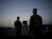 FILE - In this June 5, 2018 photo, reviewed by U.S. military officials, troops stand guard outside Camp Delta at the Guantanamo Bay detention center, in Cuba. The 20th anniversary of the first prisoners' arrival at the Guantanamo Bay detention center is on Tuesday, Jan. 11, 2022. There are now 39 prisoners left. At its peak, in 2003, the detention center held nearly 680 prisoners.