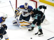 Seattle Kraken's Joonas Donskoi, right, tries to get a shot off as St. Louis Blues goaltender Ville Husso watches during the first period of an NHL hockey game Friday, Jan. 21, 2022, in Seattle.