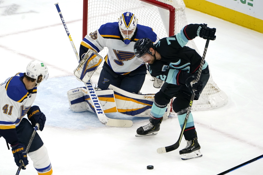 Seattle Kraken's Joonas Donskoi, right, tries to get a shot off as St. Louis Blues goaltender Ville Husso watches during the first period of an NHL hockey game Friday, Jan. 21, 2022, in Seattle.