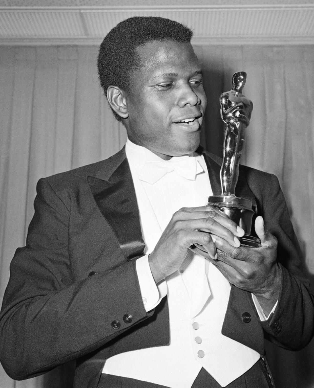 Sidney Poitier poses with his Oscar for best actor for "Lilies of the Field" at the 36th Annual Academy Awards in Santa Monica, Calif., on April 13, 1964.