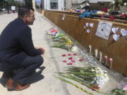 FILE - San Jose Mayor Sam Liccardo stops to view a makeshift memorial for the rail yard shooting victims in front of City Hall in San Jose, Calif., on May 27, 2021. Gun owners would be required to carry liability insurance and pay a fee under a proposed ordinance in the city of San Jose that officials say would be the first of its kind in the United States. Mayor Liccardo says it would also encourage the 5,500 households with a legally registered gun to have gun safes, trigger locks, and to take gun safety classes.