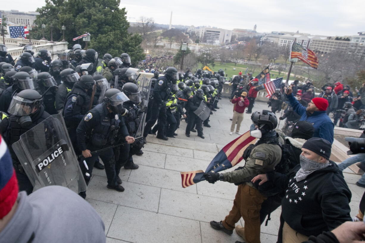 Rioters face off with police at the U.S. Capitol on Jan. 6, 2021, in Washington. A pro-Trump social media influencer who posted video of himself at the U.S.